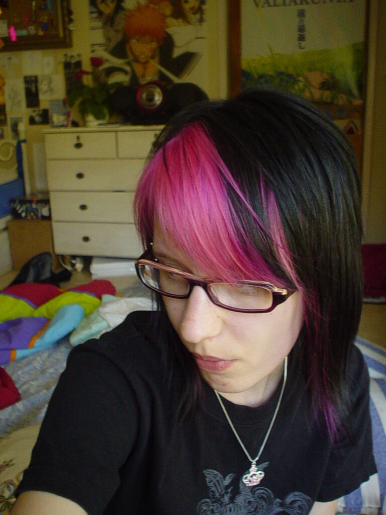Nuori nainen, jolla on pinkiksi värjätty otsatukka ja muuten mustat hiukset.